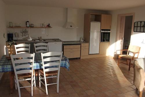 a kitchen with a table and chairs in a kitchen at Klitgaarden in Hjørring