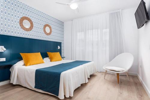 1 dormitorio azul y blanco con 1 cama y 1 silla en Cotillo House, en Cotillo