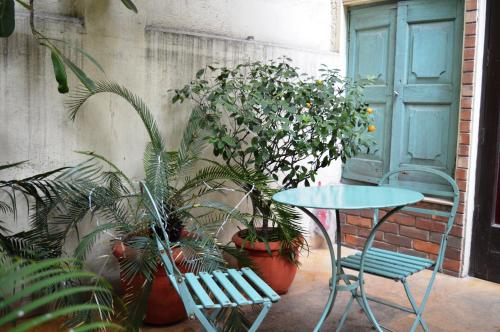 a table and a chair and some plants and a door at Zaza Stay in New Delhi