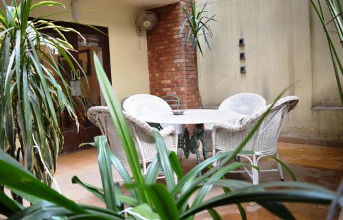 a white table and chairs in a room with plants at Zaza Stay in New Delhi
