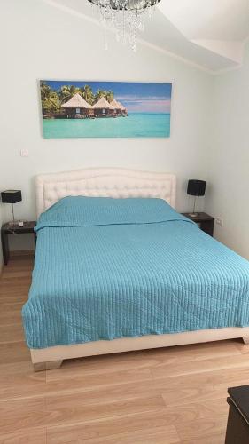 a bed with a blue comforter in a bedroom at Villa, pool and relax for 12 persons in Kuti