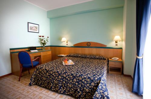 スカレアにあるHotel Talaoのベッドとデスクが備わるホテルルームです。