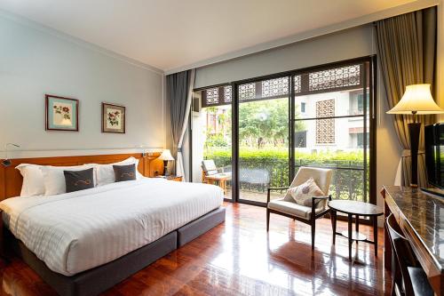 a bedroom with a bed and a large window at Plakan Resort in Kanchanaburi City