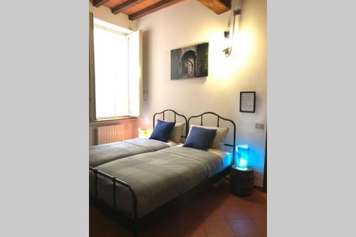 ein Schlafzimmer mit einem Bett mit blauen Kissen und einem Fenster in der Unterkunft Casa di Gil in Parma