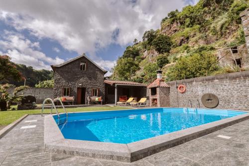 an image of a swimming pool in front of a house at Casa da Pedra by Amazing Madeira in Santana