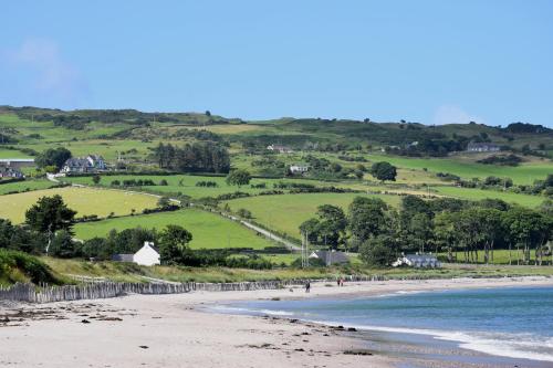 a view of a beach with people walking on the sand at Mullarts Church -The Glendun Apartment in Knocknacarry