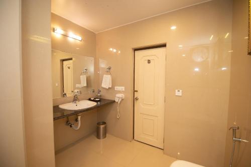 a bathroom with a sink and a mirror at The Cindrella Hotel in Siliguri