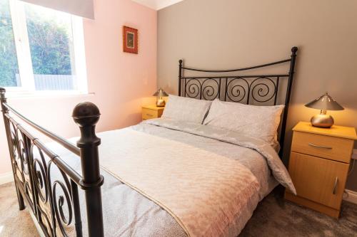 a bedroom with a bed with a black bed frame at Cosy Brixham apartment with garden close to Town in Brixham