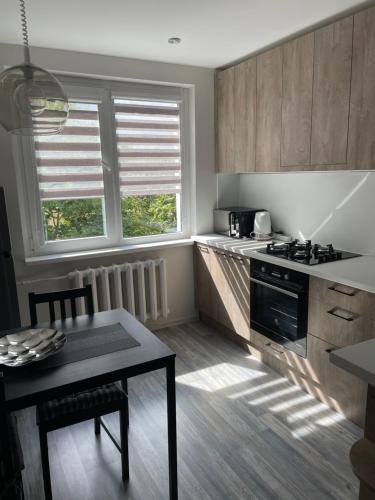a kitchen with a table and a stove top oven at Ateities 3044 Self CHECK In in Panevėžys