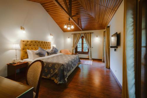 a bedroom with a large bed in a room at WelcomHeritage Ashdale in Nainital
