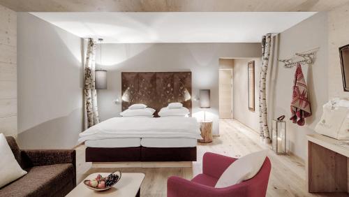 a hotel room with a large bed and a couch at INNs HOLZ in Ulrichsberg