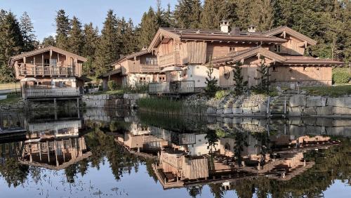 a group of wooden houses sitting next to a lake at INNs HOLZ in Ulrichsberg