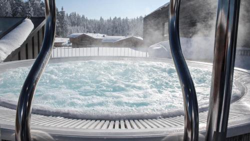 a hot tub on a deck with snow on the ground at INNs HOLZ in Ulrichsberg