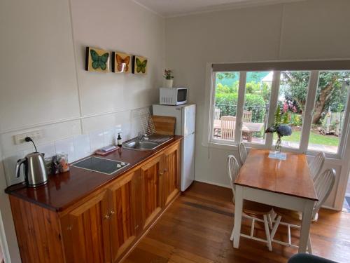 a kitchen with a sink and a table with a tableablish at Miss Bullens Cottage in Yungaburra