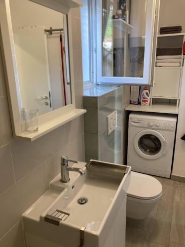 a bathroom with a sink and a washing machine at Lopud Sunset Apartment in Lopud