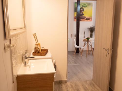 ブカレストにあるOne Love Terrace Apartmentのバスルーム(シンク、テーブル、椅子付)