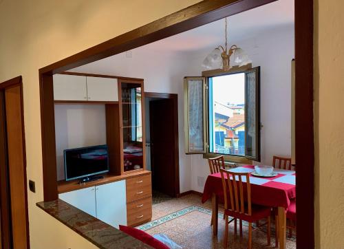 Casa Dei Nonni في سانريمو: مطبخ وغرفة طعام مع طاولة وتلفزيون