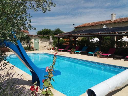 - une piscine avec un toboggan bleu à côté d'une maison dans l'établissement La Pommeraie, à Nantillé