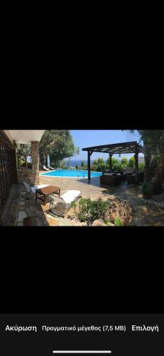 a view of a pool with a pavilion and a picnic table at Luxury villa with stunning panoramic sea view in Keratea