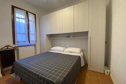 1 dormitorio con cama y ventana en 6.4.6 - Via Jodi 6, en Reggio Emilia