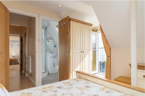 an attic bedroom with a bed and a window at Number 9 Rosemorran in St Ives