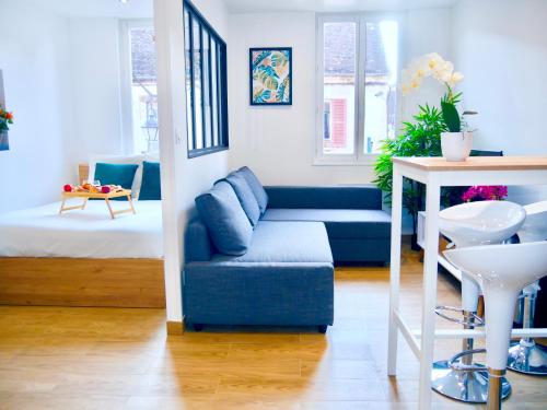 un salon avec un canapé bleu et une table dans l'établissement Oasis au Coeur de Ville Sens, à Sens
