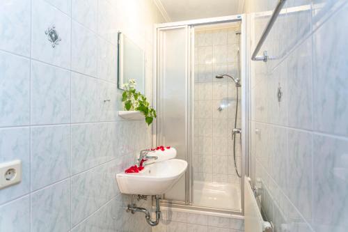 a white bathroom with a sink and a shower at Haus Schwaighofer in Saalbach Hinterglemm