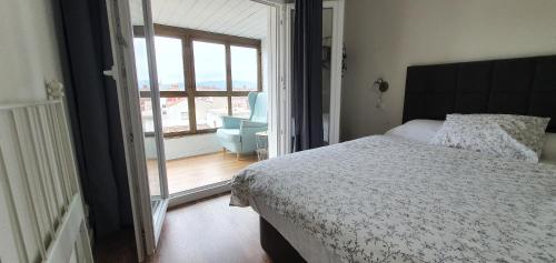 - une chambre avec un lit, une chaise et une fenêtre dans l'établissement Apartamento playa San Lorenzo, à Gijón