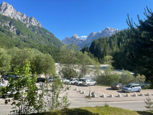 a bunch of cars parked in a parking lot with mountains at Martinov dom in Kranjska Gora