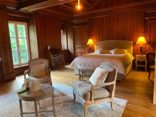 - une chambre avec un lit, une chaise et une table dans l'établissement Château de Corcelle - Chambres et table d'hôtes, à Châtenoy-le-Royal
