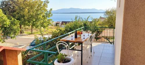 a table on a balcony with a view of the water at Apartmani ANDRIJA in Živogošće
