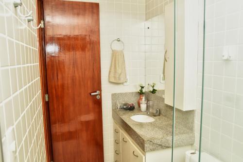 a bathroom with a sink and a glass shower at Sol de Maceió in Maceió