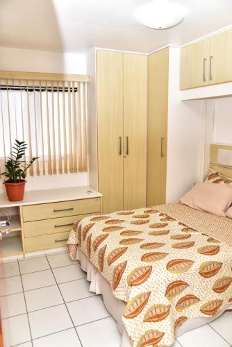 a bedroom with a bed and a desk at Sol de Maceió in Maceió