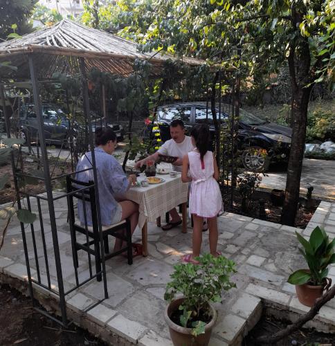 a group of people sitting at a table with a little girl at Camping late in Gjirokastër