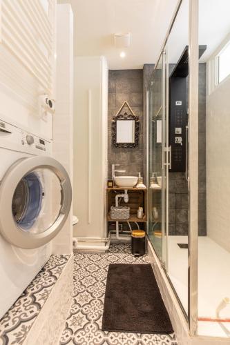 une salle de bain avec une machine à laver et un lavabo dans l'établissement La Belle Epoque, à Vichy