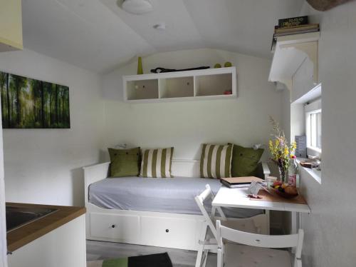 a small bedroom with a bed and a desk at Casa Foresta - minimalistisches 1-Raum Tiny House direkt am Wald in Wingst