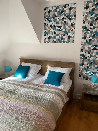 a bedroom with a bed with blue pillows at Zielone walizki in Polanica-Zdrój