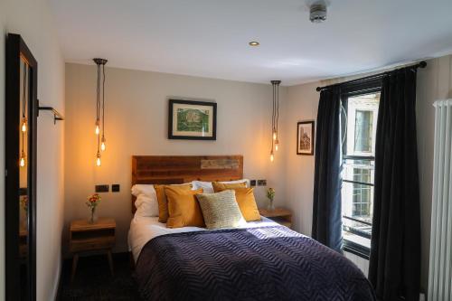a bedroom with a bed with orange pillows and a window at The Turks Head in Exeter