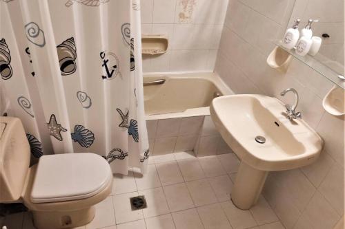 a bathroom with a sink and a toilet and a shower curtain at Apartment 95 m2, center of Sitia, WiFi, 350m beach in Sitia