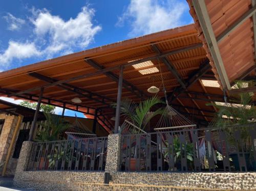 a wooden pergola on a building with chairs under it at Cabinas Pura Vida B&B and Tour Operator in Drake
