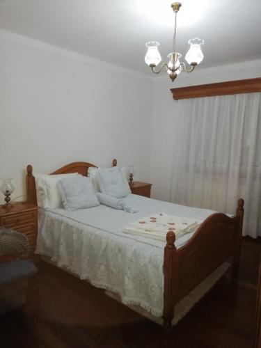 a bedroom with a bed with a chandelier at Casa do Lavrador in Casal