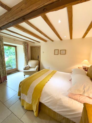 a bedroom with a large bed and a chair at The Barn in Bedale