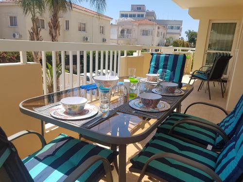 a table with cups and saucers on a balcony at Panorama Village Complex in Paralimni