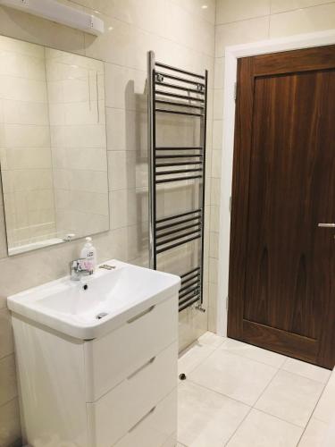 a white bathroom with a sink and a shower at Keanes Country Cottage in The Heart Of The West in Lisacul