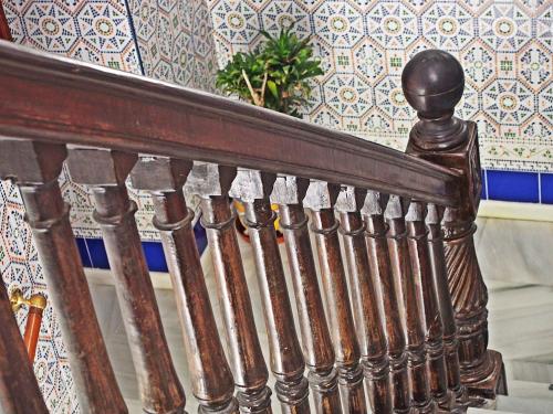 a wooden stair railing in a room with a wall at Hostal Fantoni in Cádiz