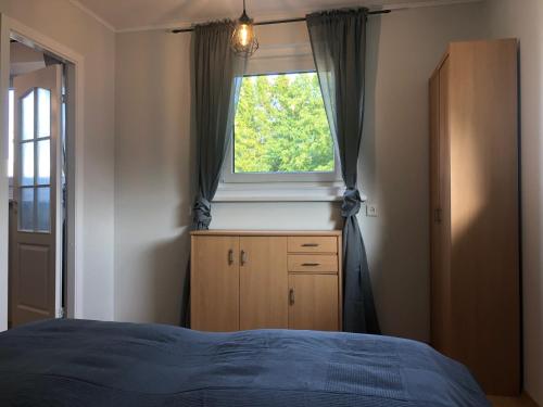 een slaapkamer met een raam, een dressoir en een bed bij Apartment Viiger in Kärdla