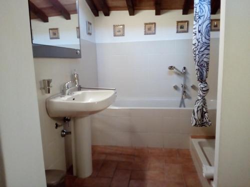 bagno con lavandino e vasca di il nido APUS Architect Apartment a Montevarchi