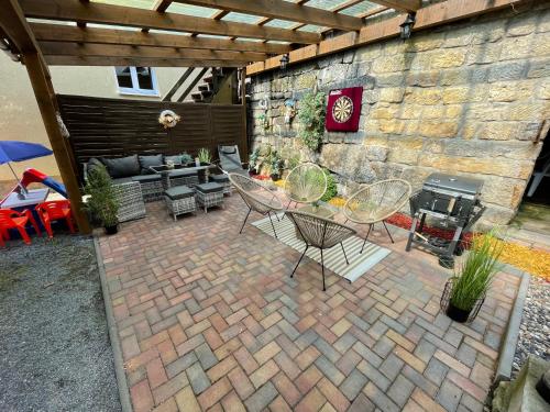 un patio con mesa, sillas y pared de piedra. en Ferienhaus Montana, en Bad Schandau