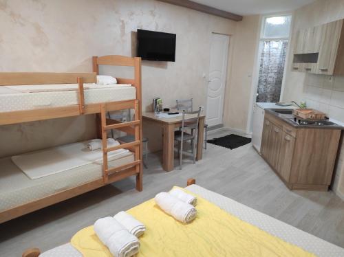 a room with two bunk beds and a kitchen at Apartment Flora Arandjelovac in Arandjelovac