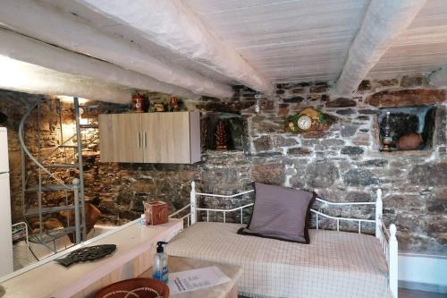 a bedroom with a bed in a stone wall at Velanidies Traditional Ikarian House in Xilosírtis